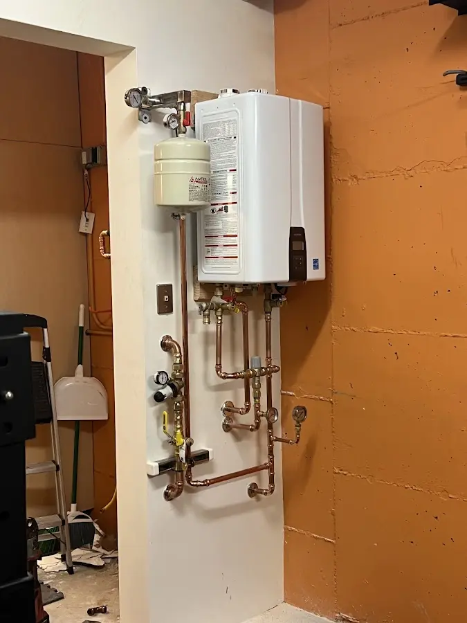Plumbing technician inspecting water heater connections in Madeira